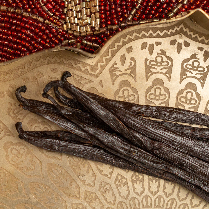 bundle of indian grade a vanilla beans with beaded and gold background