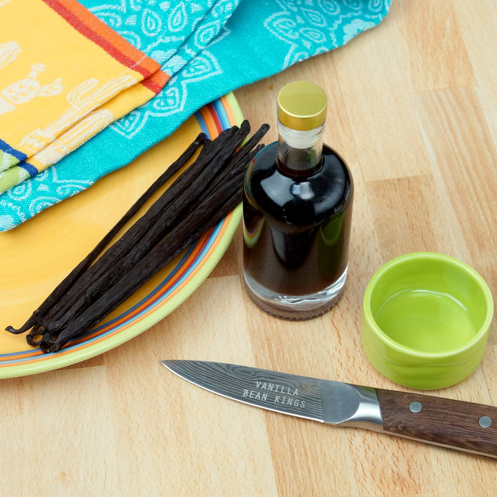 mexican vanilla beans on a plate and a bottle of vanilla extract 