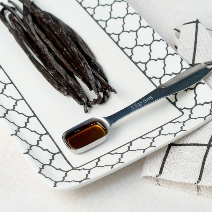 tanzania vanilla beans on a plate with 1 tsp showing vanilla extract