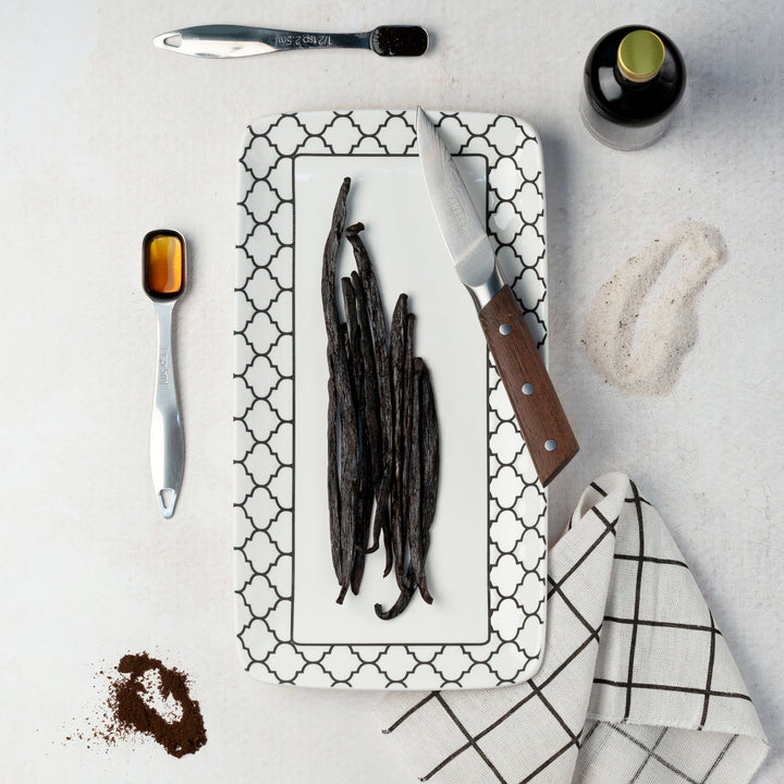 tanzania vanilla beans on a plate by a jar of vanilla extract and products on display