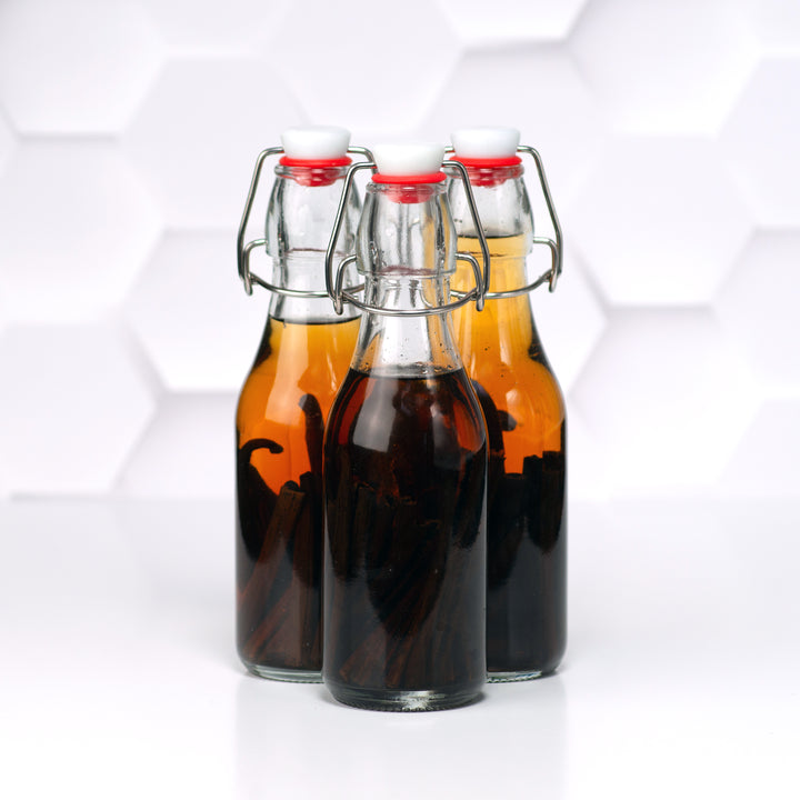 three bottles of vanilla beans extracting with white background