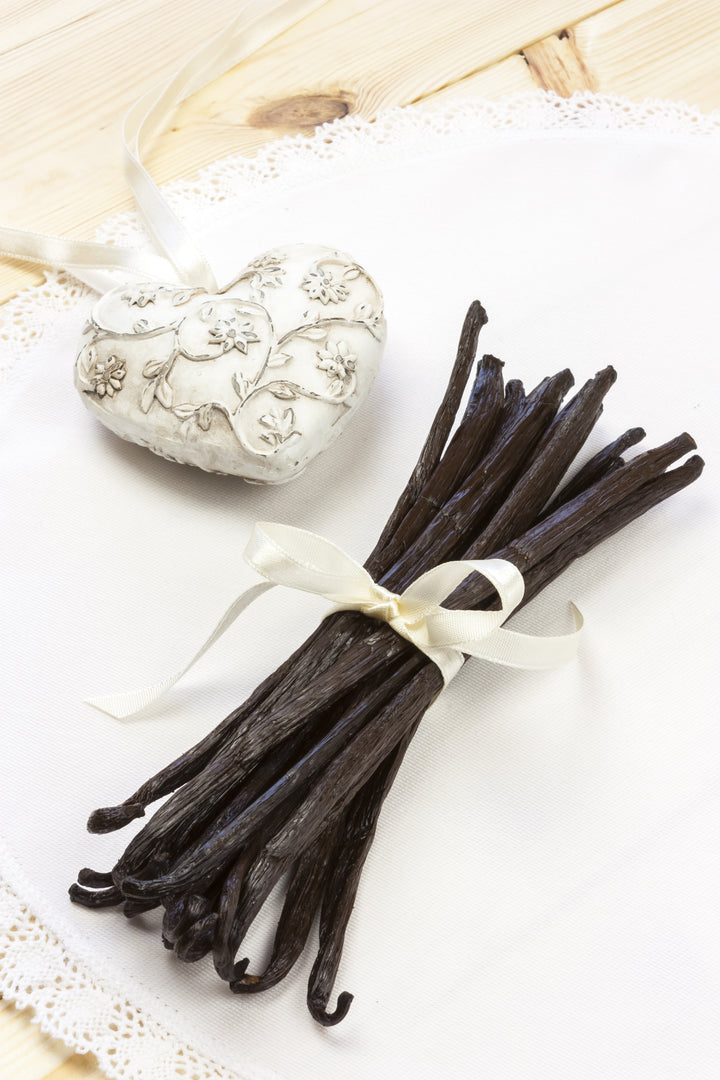 vanilla beans on table with heart locket